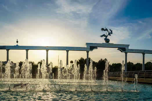 Memorial and rows of fountains illuminated by sunlight at sunset or sunrise in the Independence Square at summertime, Tashkent. photo
