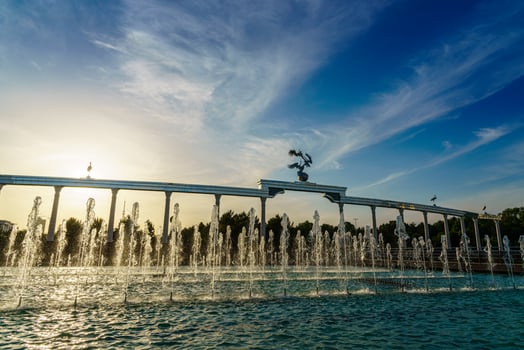 Memorial and rows of fountains illuminated by sunlight at sunset or sunrise in the Independence Square at summertime, Tashkent. photo