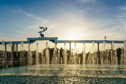 Memorial and rows of fountains illuminated by sunlight at sunset or sunrise in the Independence Square at summertime, Tashkent. photo