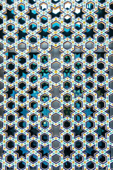 The window of a Muslim mosque behind bars in the form of a geometric hexagonal Islamic ornament. photo