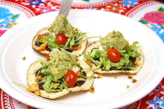 Traditional tostada, classic of Mexican cuisine with lettuce, chopped tomatoes, fried chicken chips photo