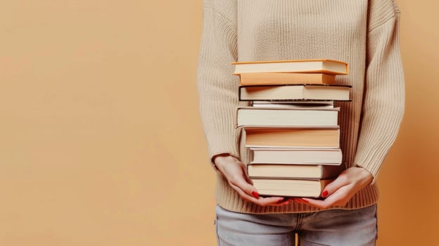 A person is holding a stack of books in their hands photo
