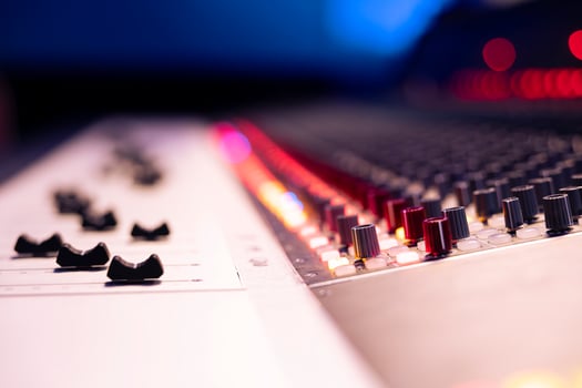 Control room desk with motorized faders and multiple knobs used in processing or editing tracks, post production concept. Panel board having buttons and sliders for recording audio. Close up. photo
