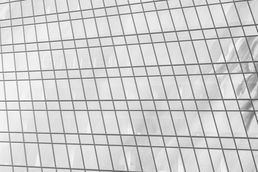 Fragment of a modern office building. Abstract geometric background. Part of a skyscraper with glass windows. Black and white. photo