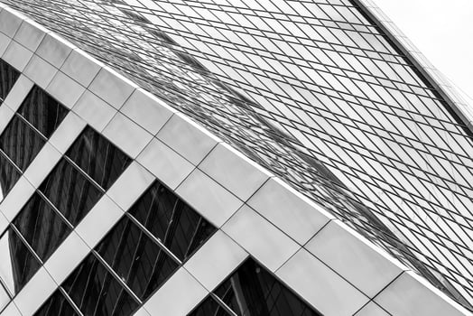 Fragment of a modern office building. Abstract geometric background. Part of a skyscraper with glass windows. Black and white. photo