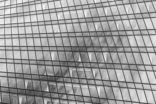 Fragment of a modern office building. Abstract geometric background. Part of a skyscraper with glass windows. Black and white. photo
