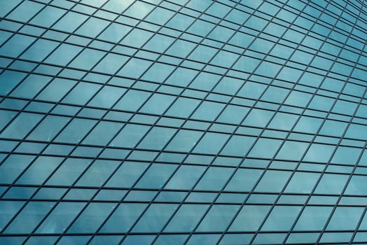 Fragment of a modern office building. Abstract geometric background. Part of a skyscraper with glass windows. photo
