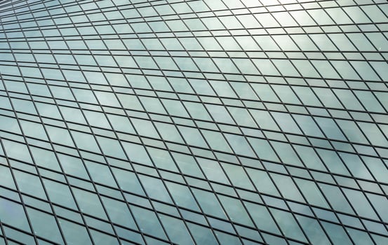 Fragment of a modern office building. Abstract geometric background. Part of a skyscraper with glass windows. photo