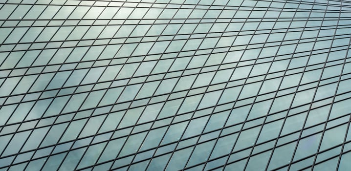 Fragment of a modern office building. Abstract geometric background. Part of a skyscraper with glass windows. photo