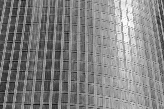 Fragment of a modern office building. Abstract geometric background. Part of a skyscraper with glass windows. Black and white. photo