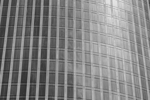 Fragment of a modern office building. Abstract geometric background. Part of a skyscraper with glass windows. Black and white. photo