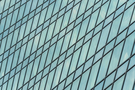 Fragment of a modern office building. Abstract geometric background. Part of a skyscraper with glass windows. photo