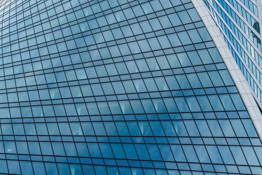 Fragment of a modern office building. Abstract geometric background. Part of a skyscraper with glass windows. photo