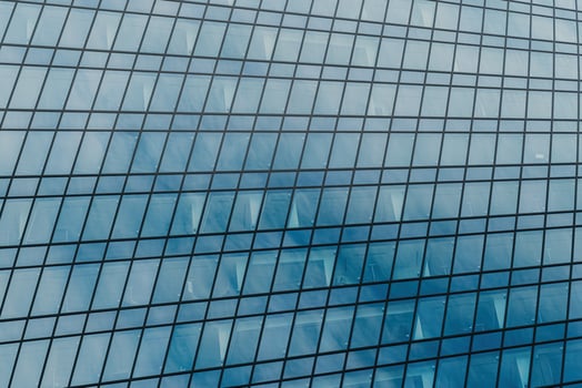 Fragment of a modern office building. Abstract geometric background. Part of a skyscraper with glass windows. photo