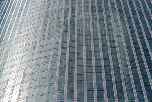 Fragment of a modern office building. Abstract geometric background. Part of a skyscraper with glass windows. photo