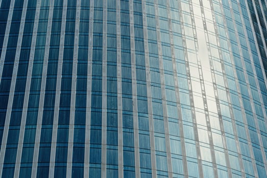 Fragment of a modern office building. Abstract geometric background. Part of a skyscraper with glass windows. photo