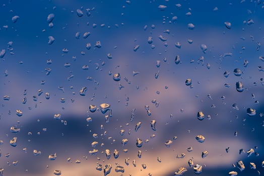 Raindrops on a window with a sunset sky in the background. photo