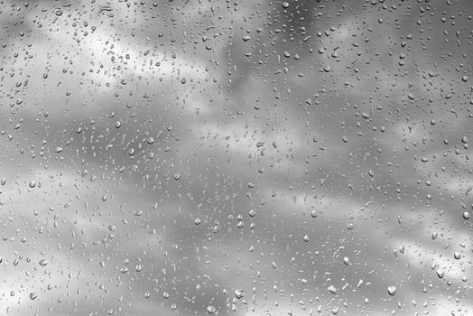 Raindrops on glass in cloudy rainy weather. Autumn weather concept. photo