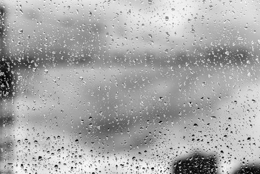 Raindrops on glass in cloudy rainy weather. Autumn weather concept. photo