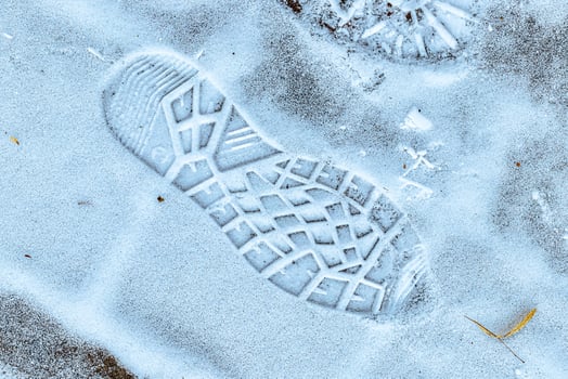 Boot track on thin first snow in winter. photo