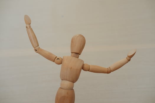 Wooden mannequin standing on a wooden background. Selective focus. photo