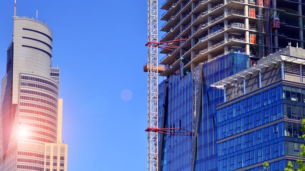 High rise building under construction. Installation of glass facade panels on a reinforced concrete structure. photo