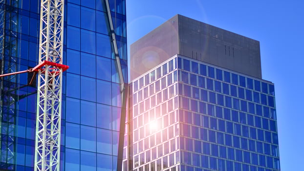 High rise building under construction. Installation of glass facade panels on a reinforced concrete structure. photo