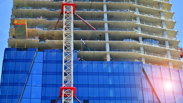 High rise building under construction. Installation of glass facade panels on a reinforced concrete structure. photo