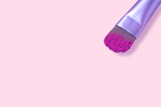 cosmetic brushes with pink powder on light pink background, place for text photo