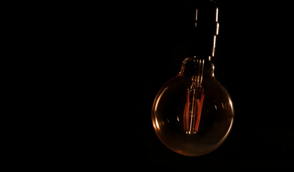 Unlit glass bulb without electricity hanging with warm reflections photo