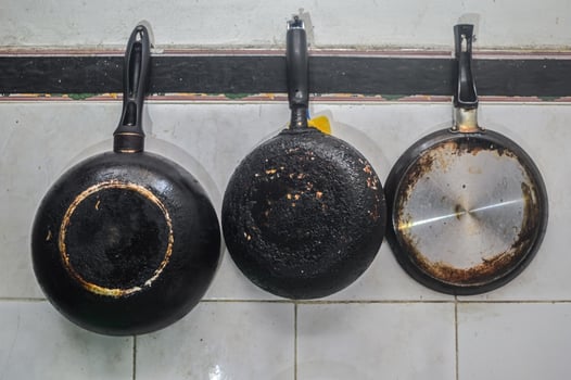 three Teflon or frying pans hanging in the kitchen photo