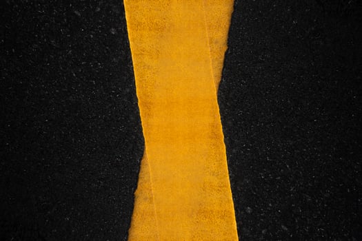 Yellow traffic lines on the dark asphalt road background photo