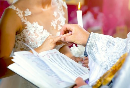 Newlyweds stand before the priest on a wedding ceremony and exchange the rings photo