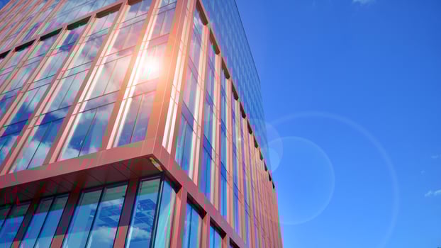 Glass building with transparent facade of the building and blue sky. Structural glass wall reflecting blue sky. Abstract modern architecture fragment. Contemporary architectural background. photo