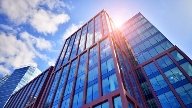 Glass building with transparent facade of the building and blue sky. Structural glass wall reflecting blue sky. Abstract modern architecture fragment. Contemporary architectural background. photo