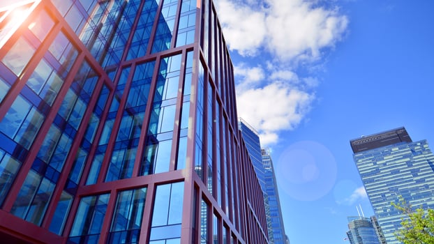 Glass building with transparent facade of the building and blue sky. Structural glass wall reflecting blue sky. Abstract modern architecture fragment. Contemporary architectural background. photo