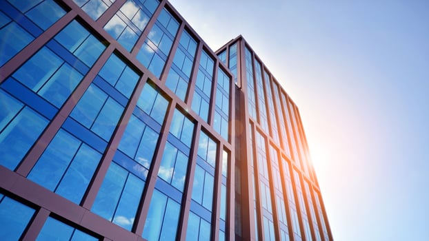 Glass building with transparent facade of the building and blue sky. Structural glass wall reflecting blue sky. Abstract modern architecture fragment. Contemporary architectural background. photo