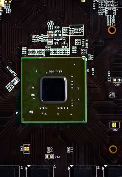 A brown printed circuit board with a processor chip and memory strips. Electronic components on the graphics card. photo