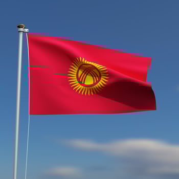 Kyrgyzstan Flag is waving in front of a blue sky with blurred clouds in the background photo
