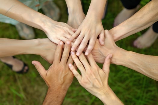 A group of people are holding hands in a circle photo