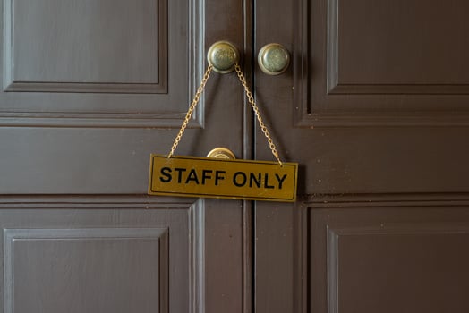 Staff only gold label hanging on knob in front of staff room photo