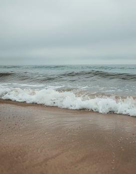 Person Standing on Beach Holding Surfboard photo