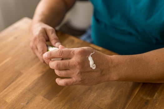 skin care, hands smeared with cream on dark background photo
