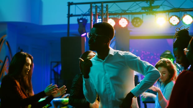 Young people partying at nightclub having fun and drinking alcohol at bar, energetic friends dancing and enjoying nightlife. Persons partying on the dance floor, funky clubbing. photo