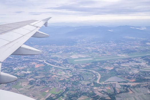 Aerial view of agricultural fields, river, mountains, and land have seen through the airplane window photo