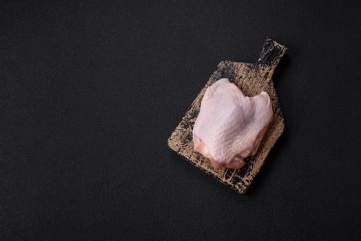Fresh raw chicken thighs with salt and spices photo