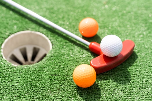 Mini-golf ball on artificial grass. Summer season game photo