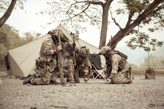 Soldiers in camouflage uniforms planning on operation in the camp, soldiers training in a military operation photo