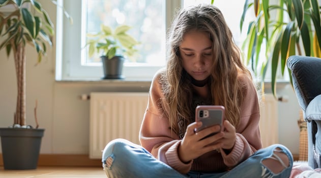 Teenager browsing internet on mobile device and playing with smartphone apps photo
