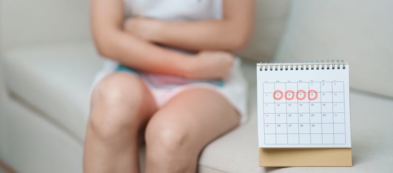 Menstruation period cycle of monthly and Stomachache concepts. woman having abdomen pain with hot water bottle and calendar, illness female suffer from premenstrual ache and body Health problem photo